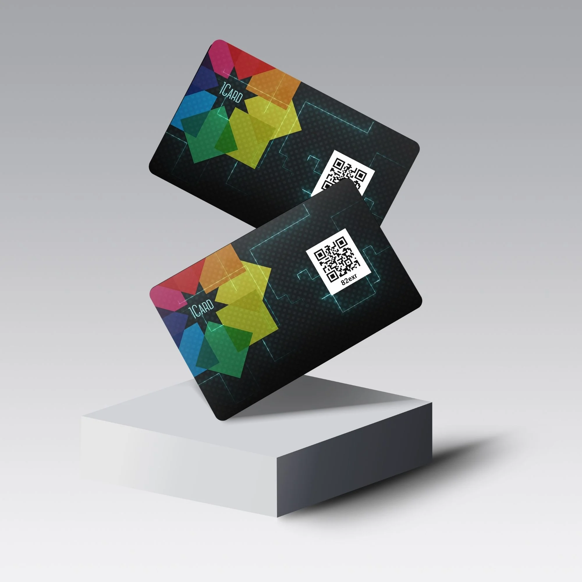 Two black 1Card Eco cards with colorful geometric designs and QR codes, displayed on a white pedestal against a gray background.