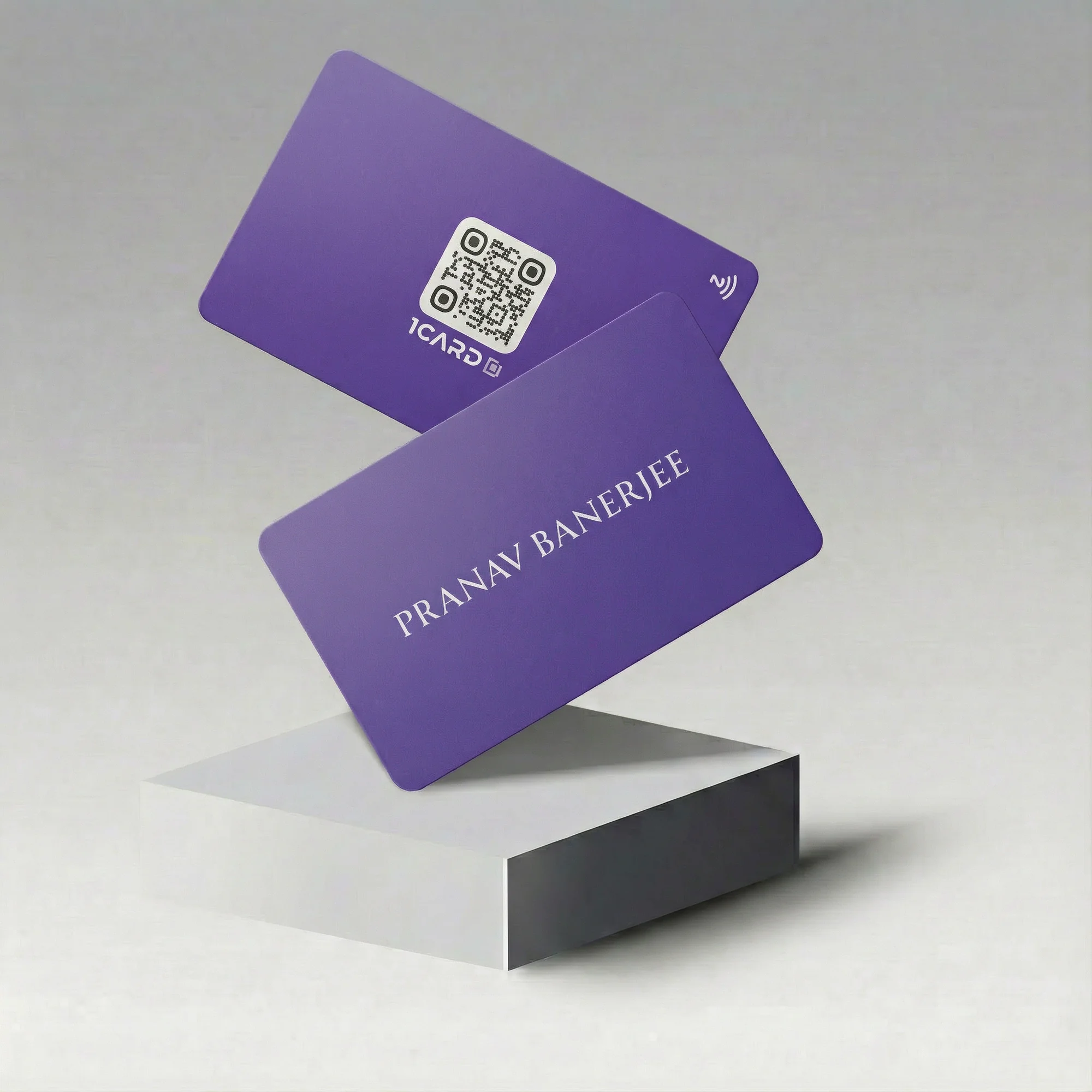 Two purple NFC business cards with a QR code and the name "Pranav Banerjee" displayed on a white platform.