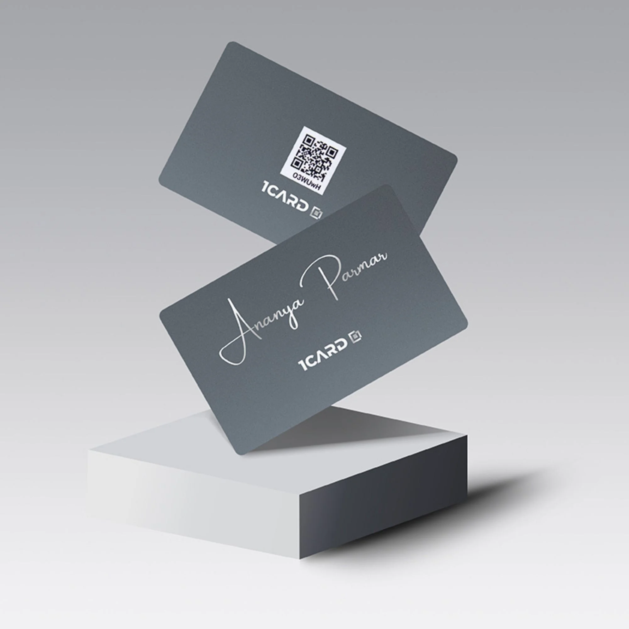 Two gray 1Card Regal Opulence cards with a QR code and "Ananya Parmar" text, displayed on a white podium.