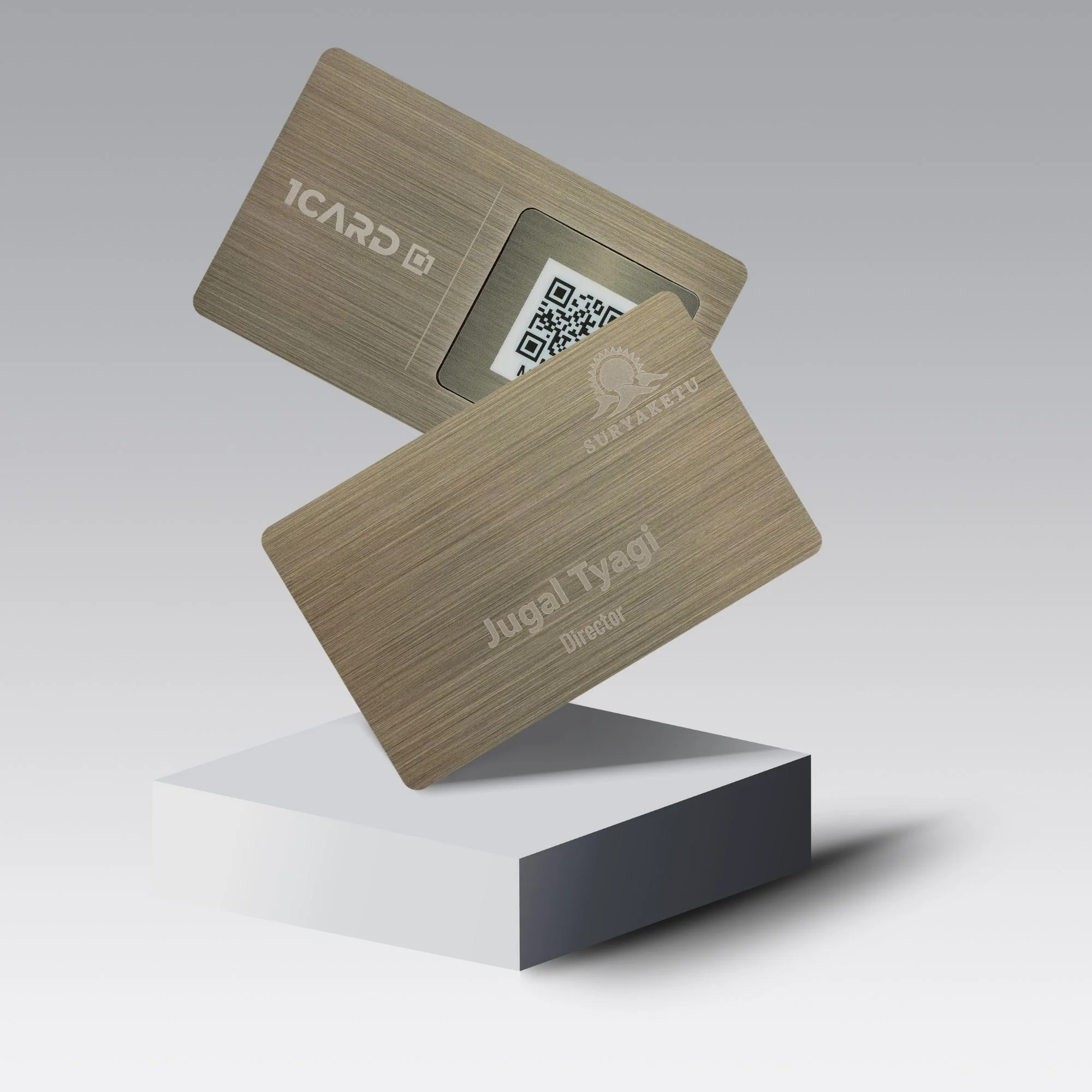 Two stainless steel cards with engraved text and a visible QR code, displayed on a white pedestal against a gradient background.